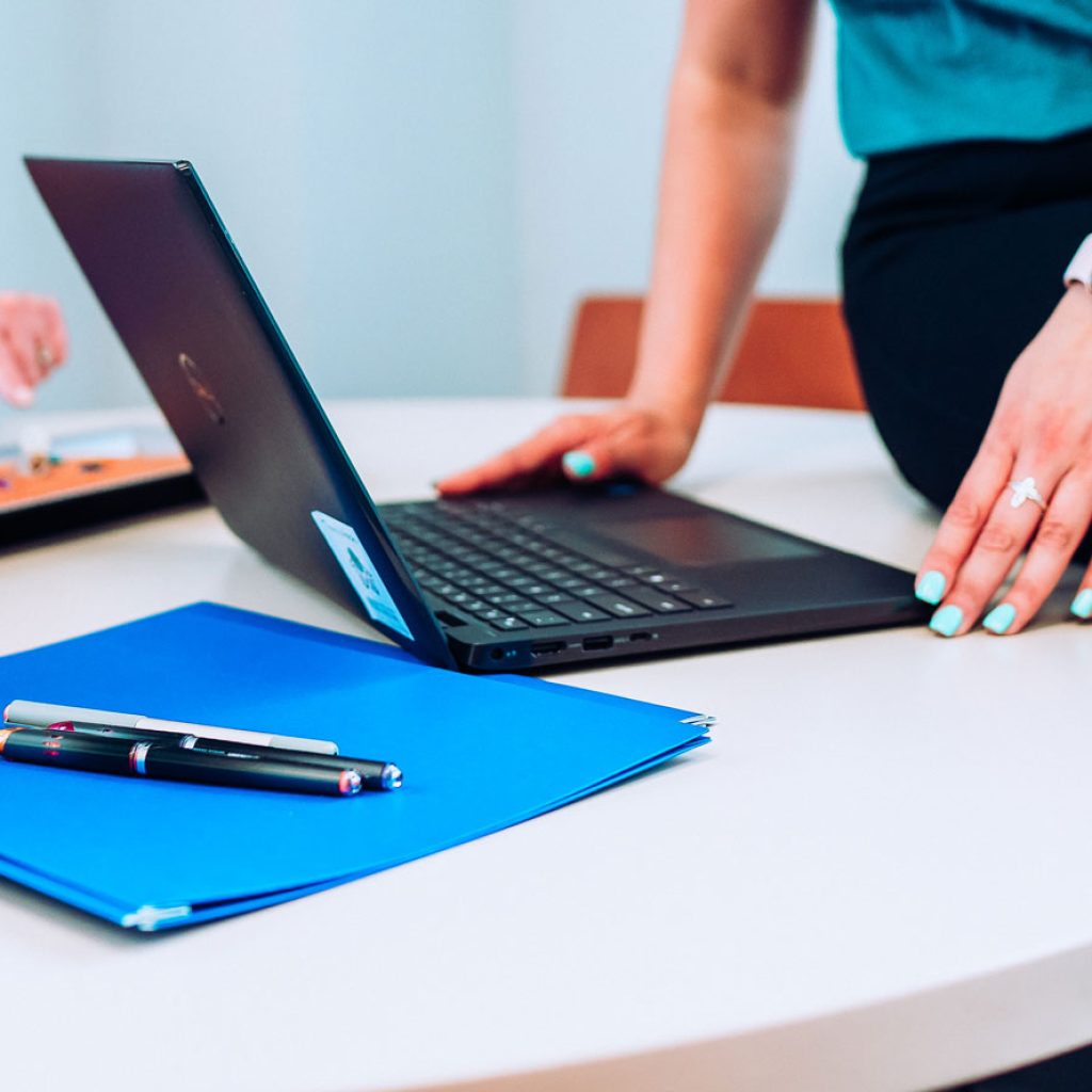 computer-sitting-on-table-next-to-folder